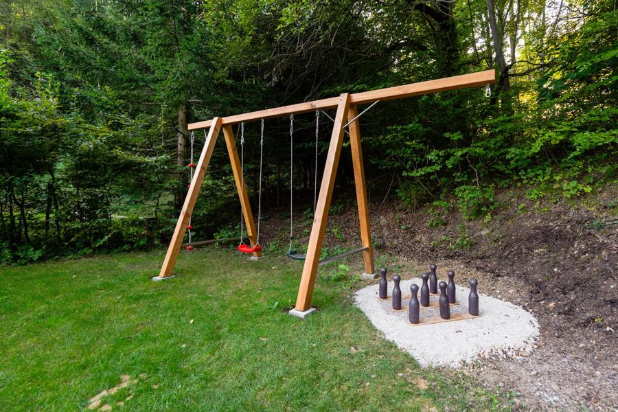 Dřevěná houpačka a kuželky na okraji lesa